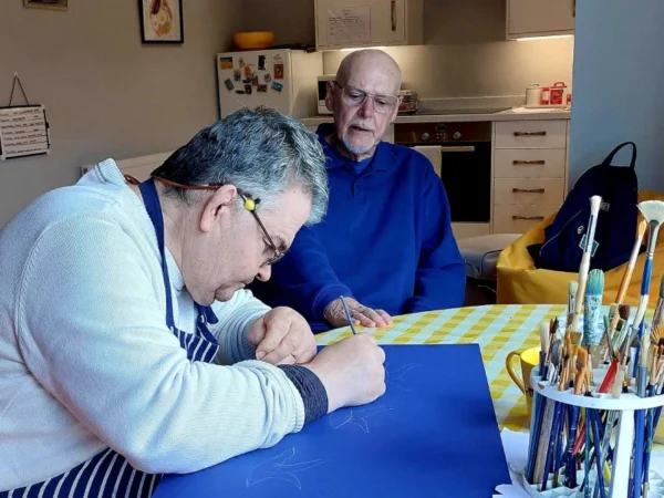 A person supported by Style Acre having an art lesson with a volunteer - Style Acre
