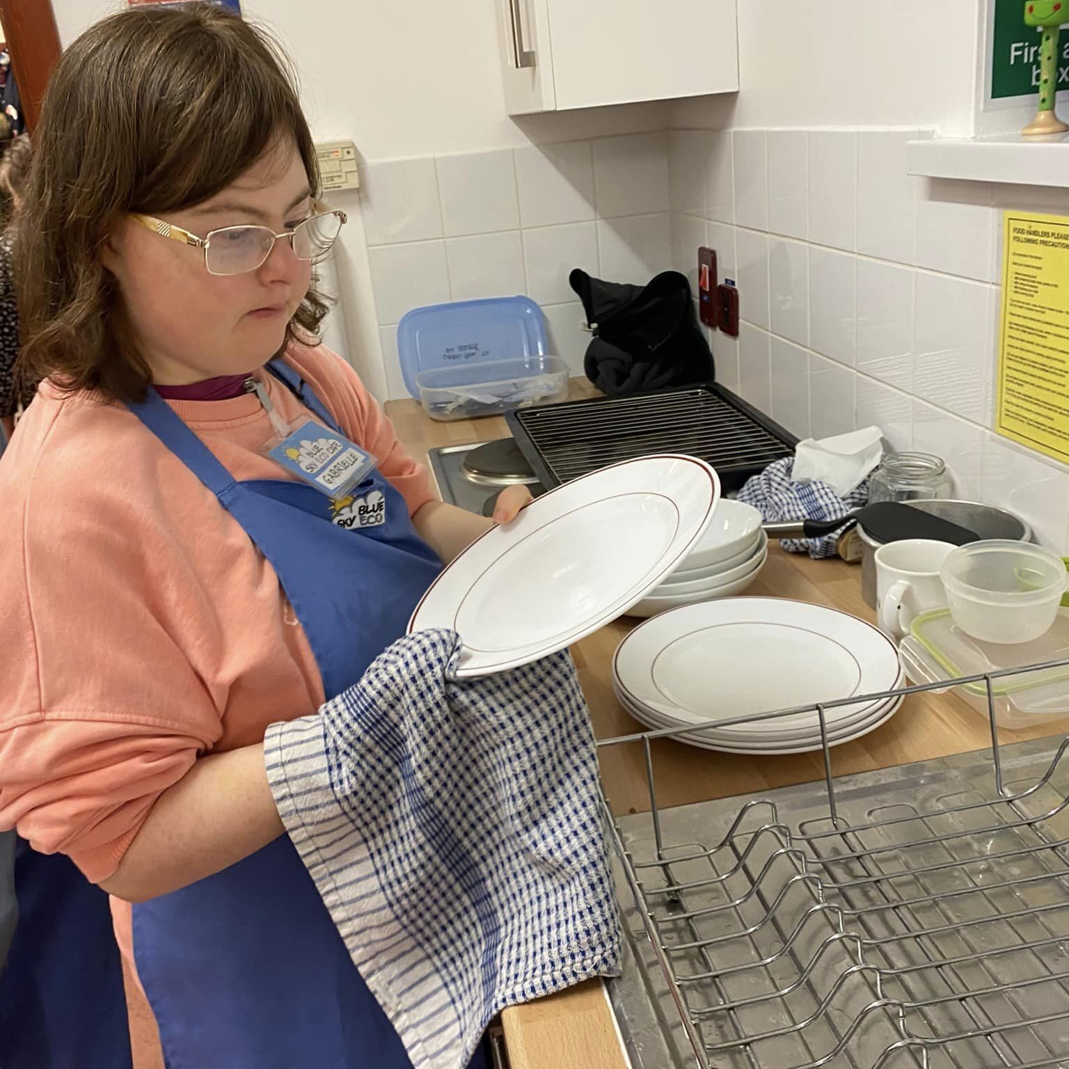 A lady drying up in a commercial kitchen - Employment support in Oxfordshire, Style Acre