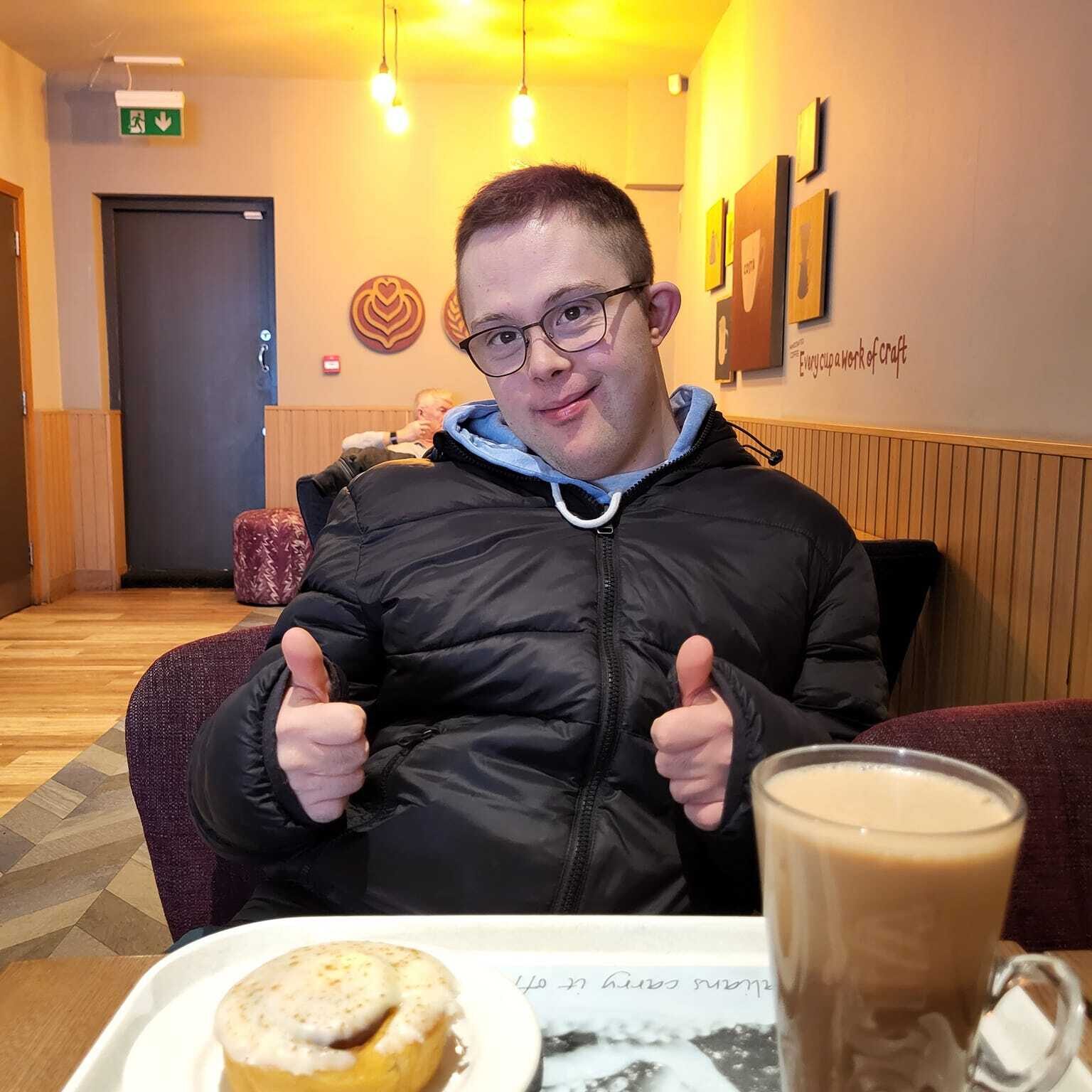 A man enjoying a coffee and cake with community support in Oxfordshire