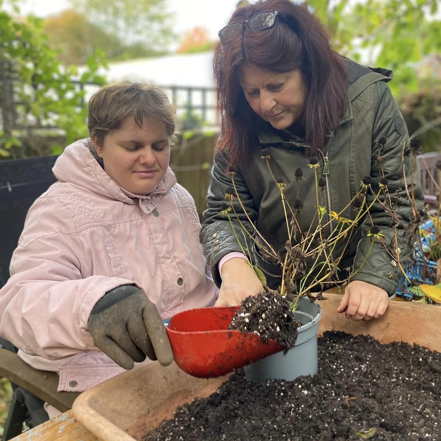 Two ladies potting up a plant at Wantage Market Garden project, Oxfordshire