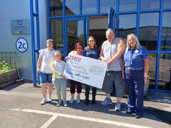 The team at T2 our community hub holding a cheque from a corporate company who has been fundraising for Style Acre.