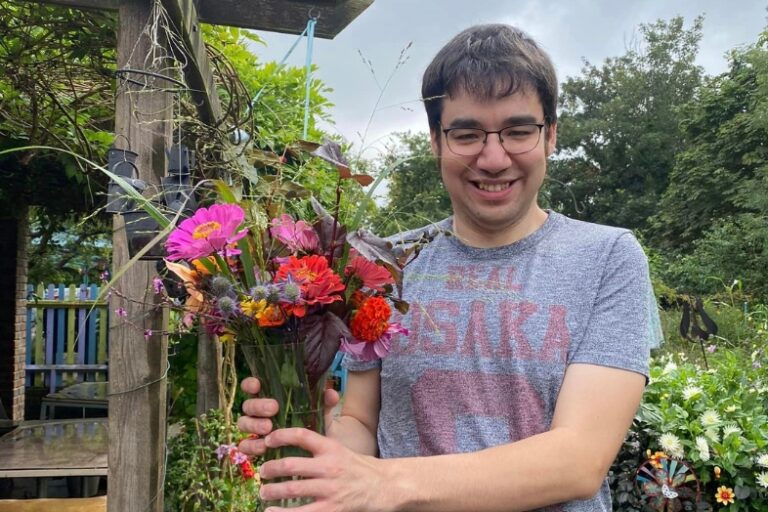 AA person volunteering at a garden holding flowers