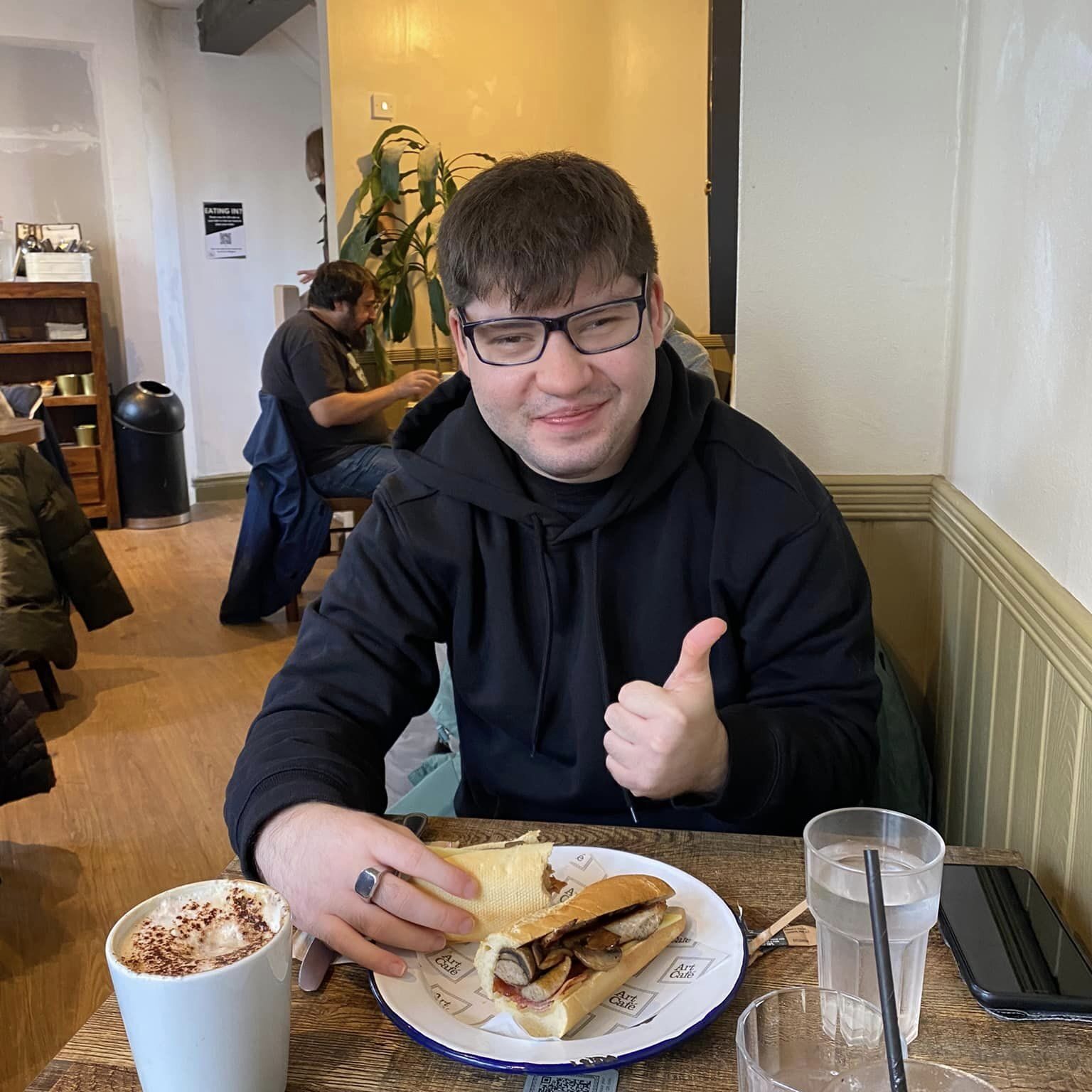 A gentleman enjoying breakfast at a café with community support in Oxfordshire.