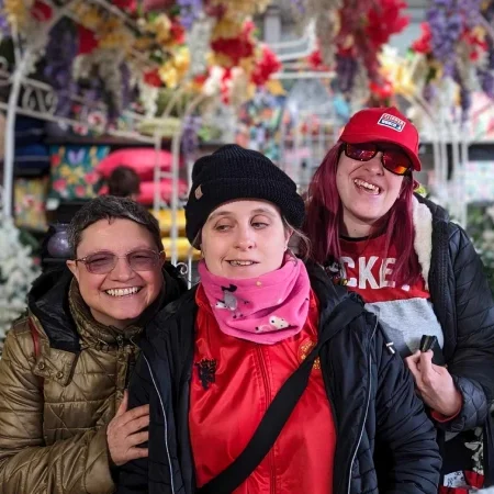 Friends on a day out at a garden centre under a flower arch