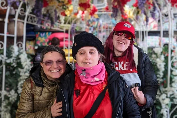 Friends on a day out at a garden centre under a flower arch