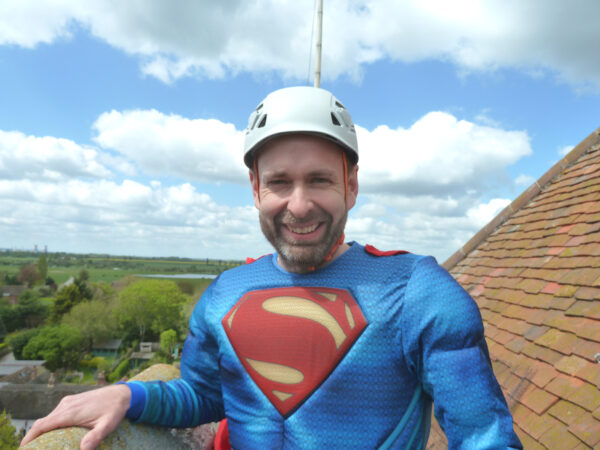 A gentleman dressed in a superman costume ready to do an abseil fundraising for Style Acre
