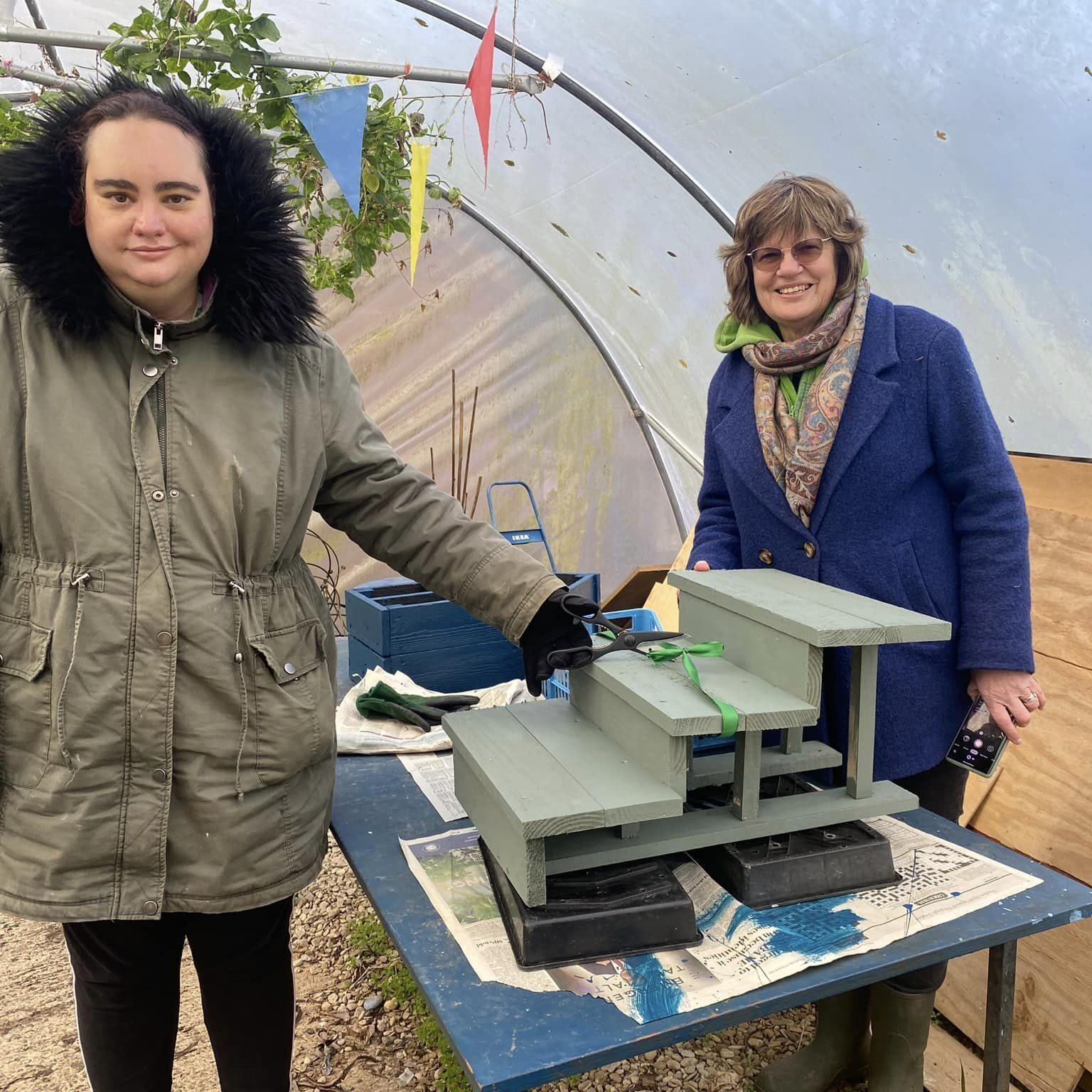 Two ladies with a plant stand for displaying mint at the Wantage Market Garden project, Oxfordshire