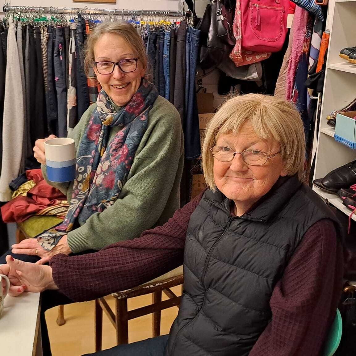 Two people taking a break with a cup of tea at the Style Acre Charity Shop