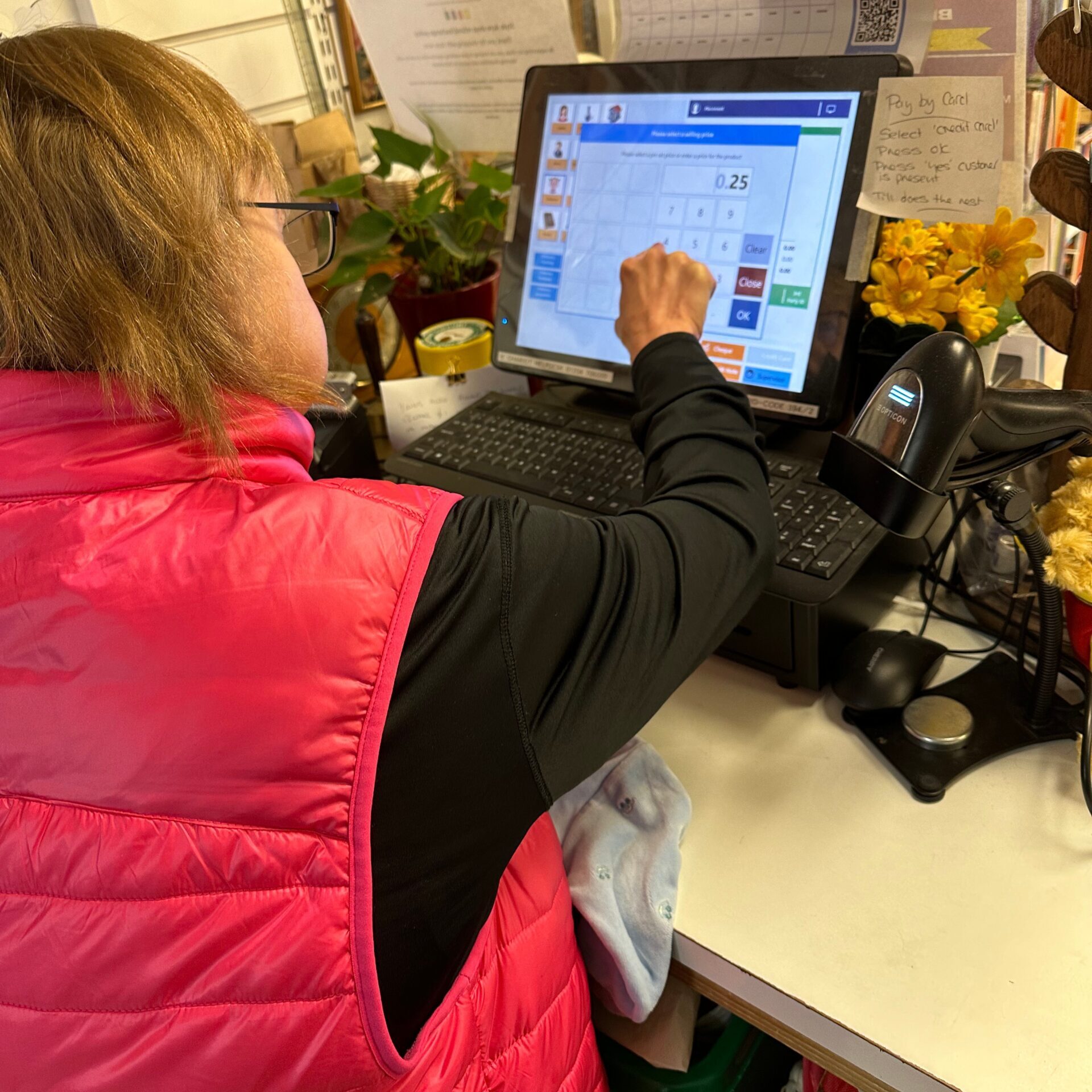 A lady using the till at the Style Acre Charity Shop