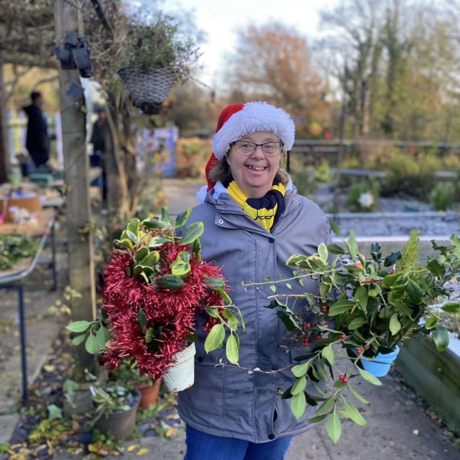 A lady enjoying gardening skills and showing her Christmas plants at Wantage Market Garden in Oxfordshire