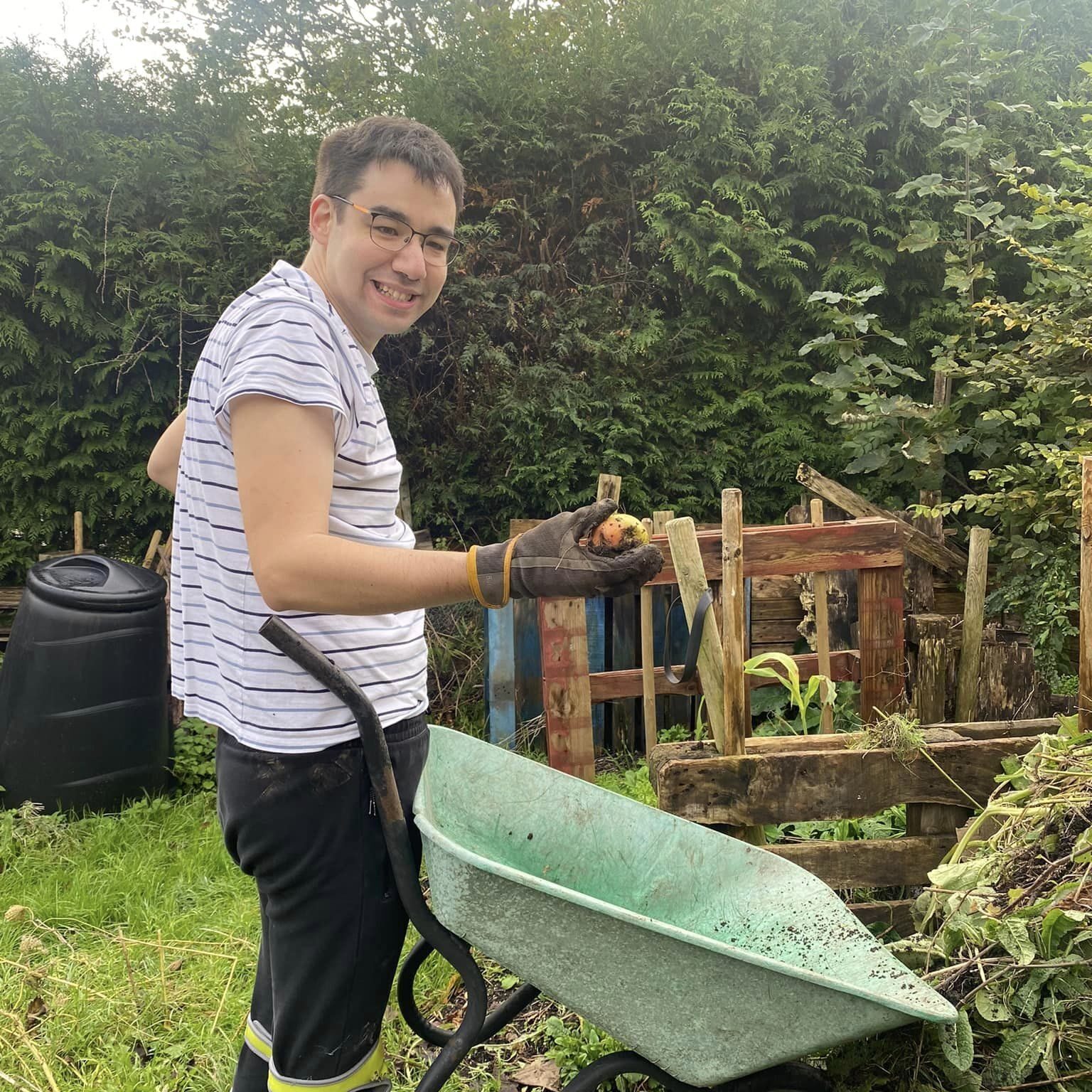 A man with a wheelbarrow learning new gardening skills in Oxfordshire