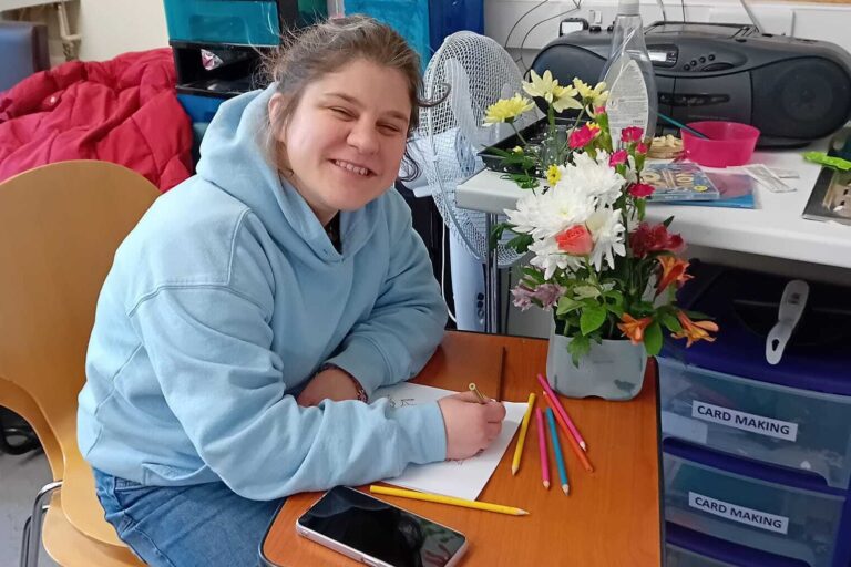 Someone we support enjoying crafts and flower arranging at one of our community hubs.