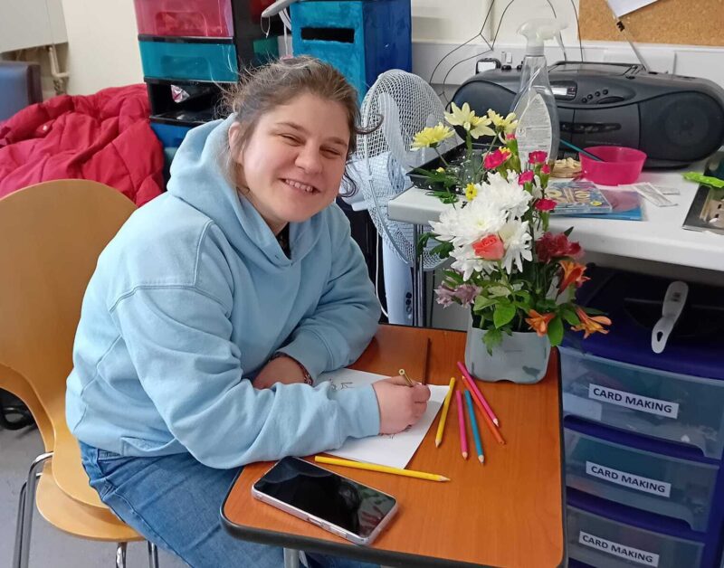 Someone we support enjoying crafts and flower arranging at one of our community hubs.