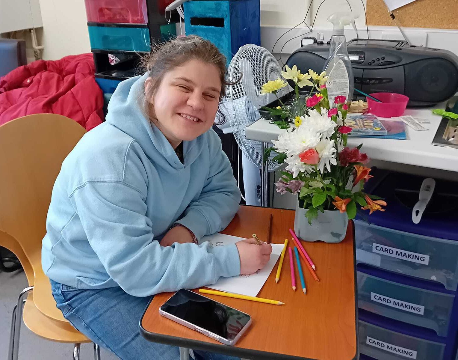 Someone we support enjoying crafts and flower arranging at one of our community hubs.