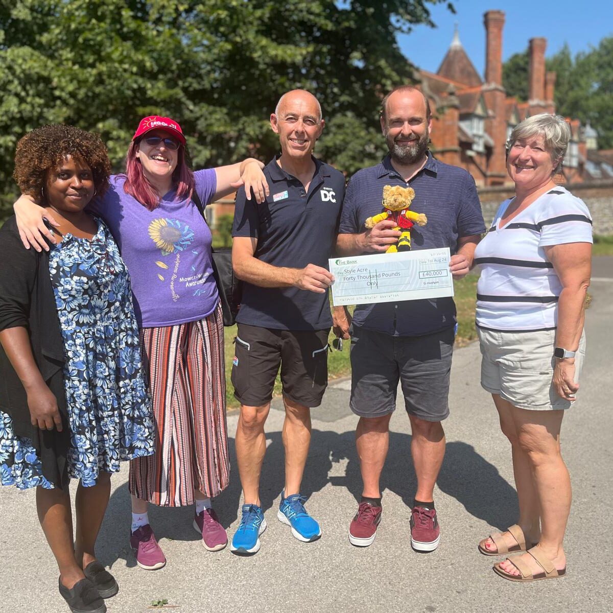 People receiving a cheque from fundraised money
