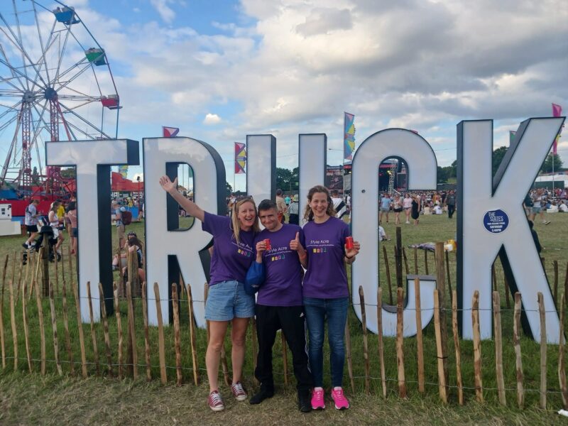 Three people in front of the Truck sign