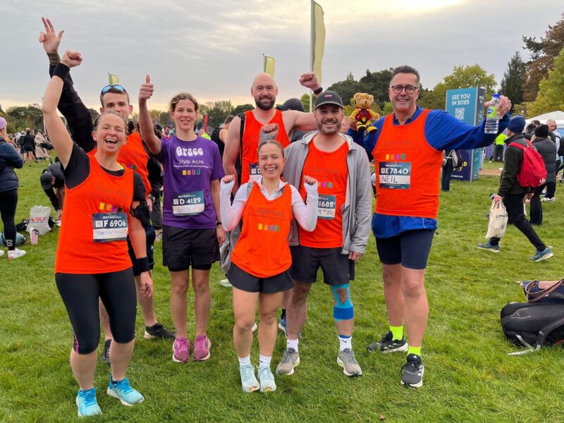 Team of six men and women cheering as they get ready to run the oxford half marathon.