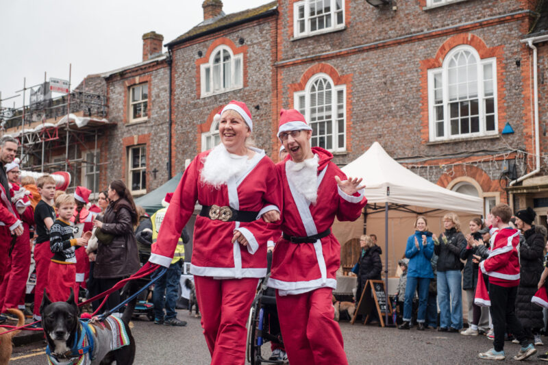 tow people and their dog running to the finish line