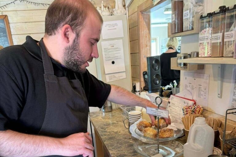 Gentleman volunteering at the Tea Room displaying scones