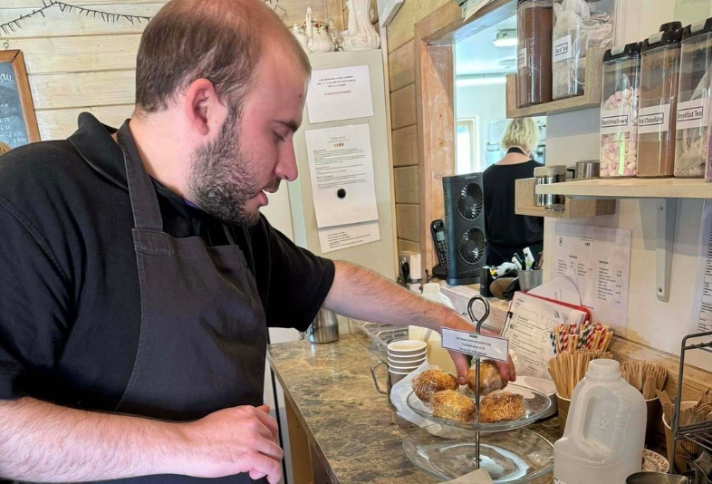 Gentleman volunteering at the Tea Room displaying scones