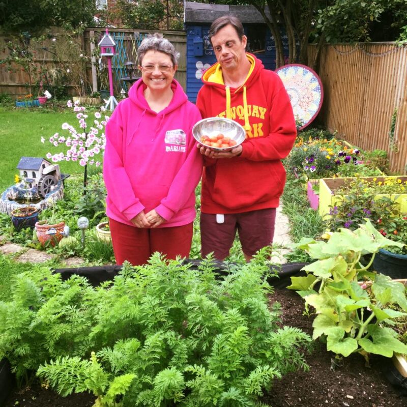 Two people supported by Style Acre next to their vegetable patch