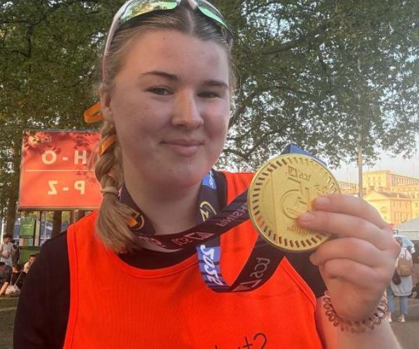 Square images for wesbite (600 x 500 px) A lady called Holly, standing in a bright orange Style Acre running vest holding up her London Marathon 2025 medal