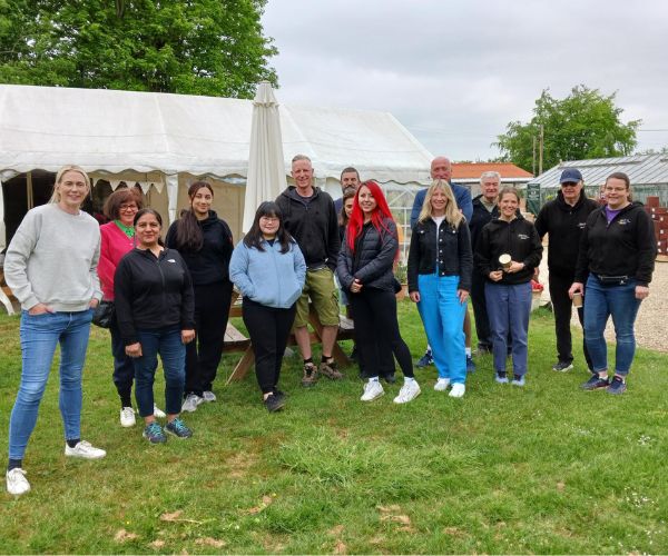 Group of 15 volunteers from Natwest standing outside the tea room