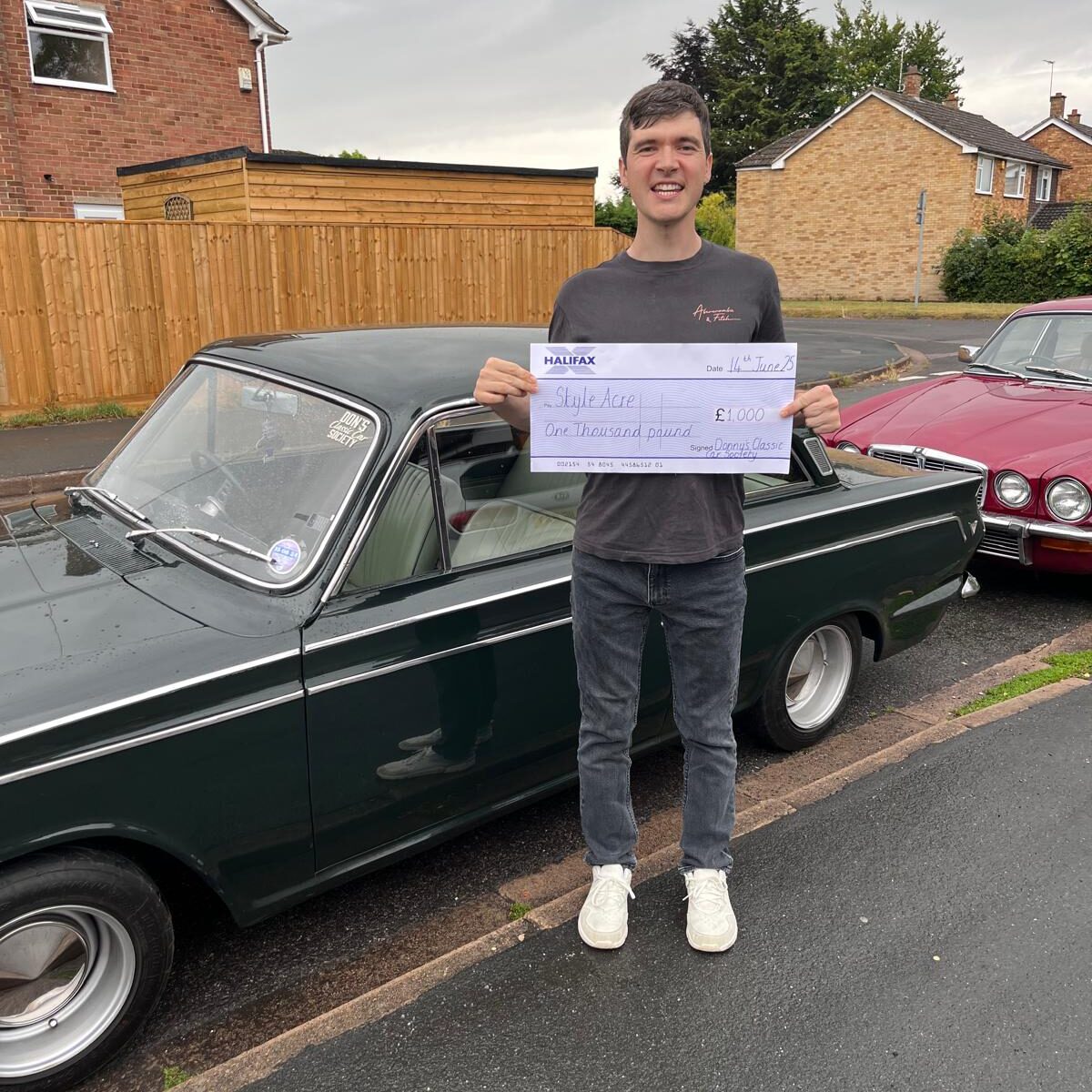 Someone supported by Style Acre receiving the £1,000 cheque from Donny's classic car show