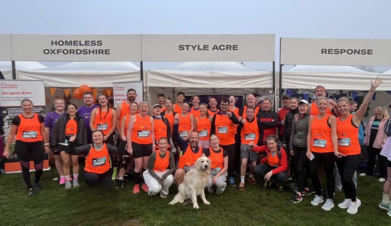 Team of 50 runners in bright orange running vests.