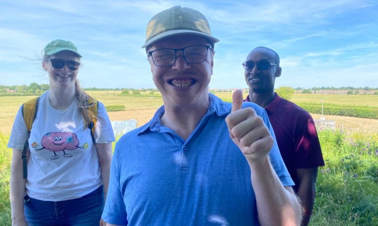 Didcot walk Matty Person giving thumbs up stood with two people and countryside behind them