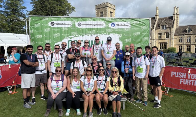 Seb 1 A group of 22 men and women stanging infront of a Cotswold Way Ultra Challenge Sign.