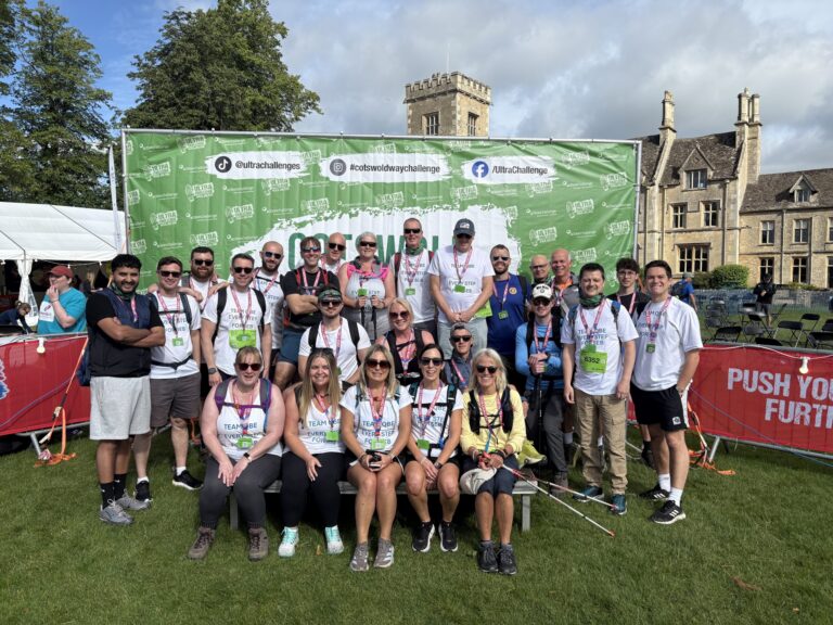 Seb 1 A group of 22 men and women stanging infront of a Cotswold Way Ultra Challenge Sign.