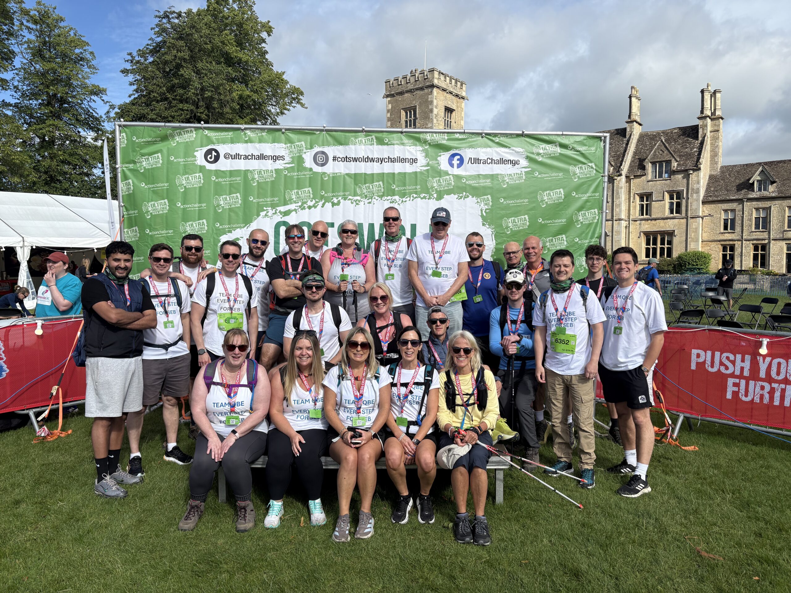 Seb 1 A group of 22 men and women stanging infront of a Cotswold Way Ultra Challenge Sign.