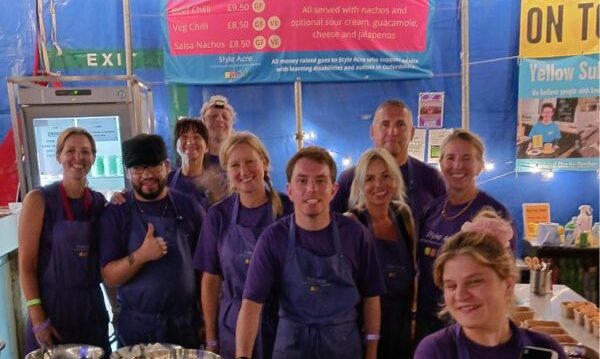 New Articles website (600 x 500 px) (2) A team of 10 volunteers standing together at the Truck Festival chilli nacho stand.