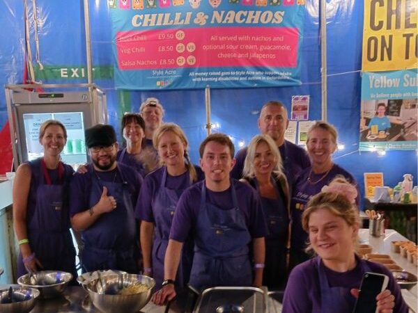 New Articles website (600 x 500 px) (2) A team of 10 volunteers standing together at the Truck Festival chilli nacho stand.