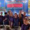 A team of 10 volunteers standing together at the Truck Festival chilli nacho stand.