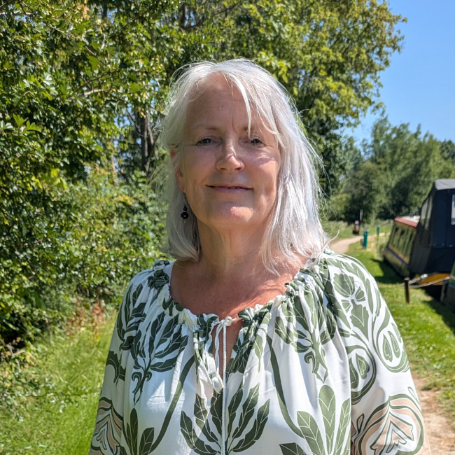 Woman standing in front of green hedge