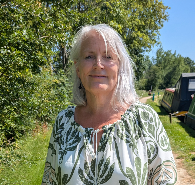 Woman standing in front of green hedge