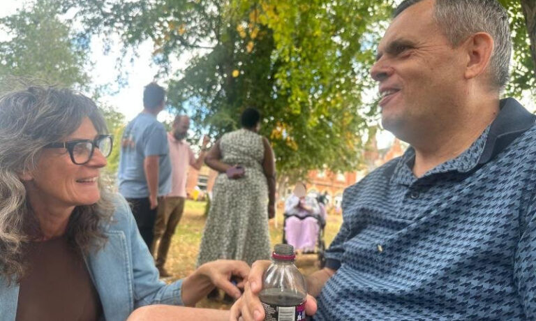 c b edited Two people chatting under trees at a picnic
