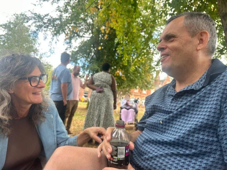c b edited Two people chatting under trees at a picnic