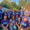 A group photo of 14 people from Vertex standing and kneeling in the wantage market garden