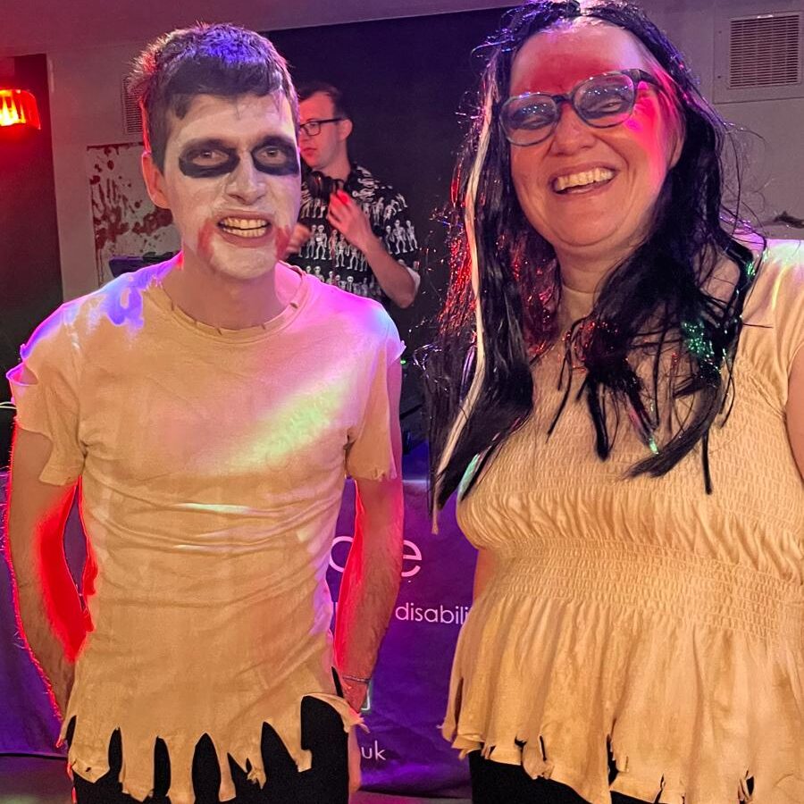 A man and women stood together dressed up as Zombies