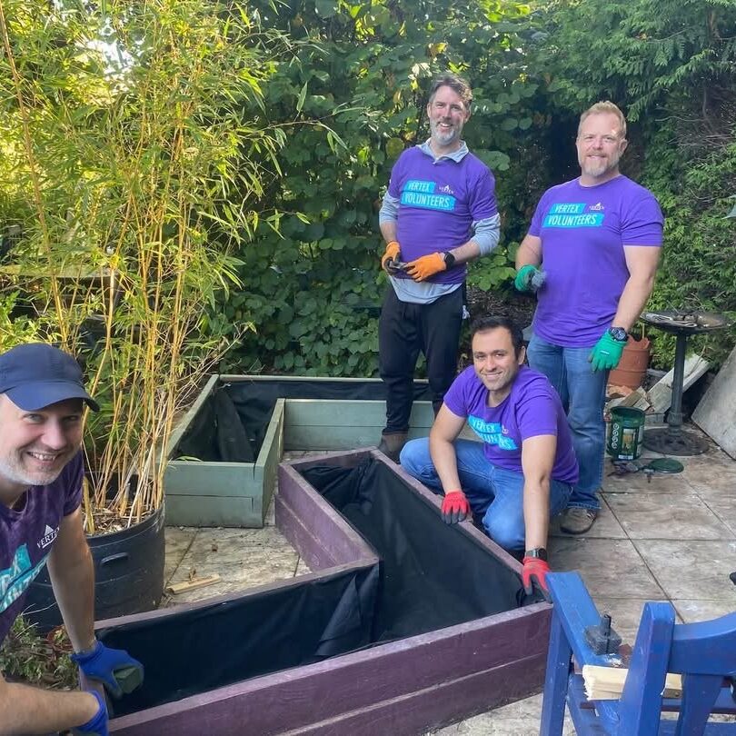 4 men in purple t-shirts from Vertex painting planters